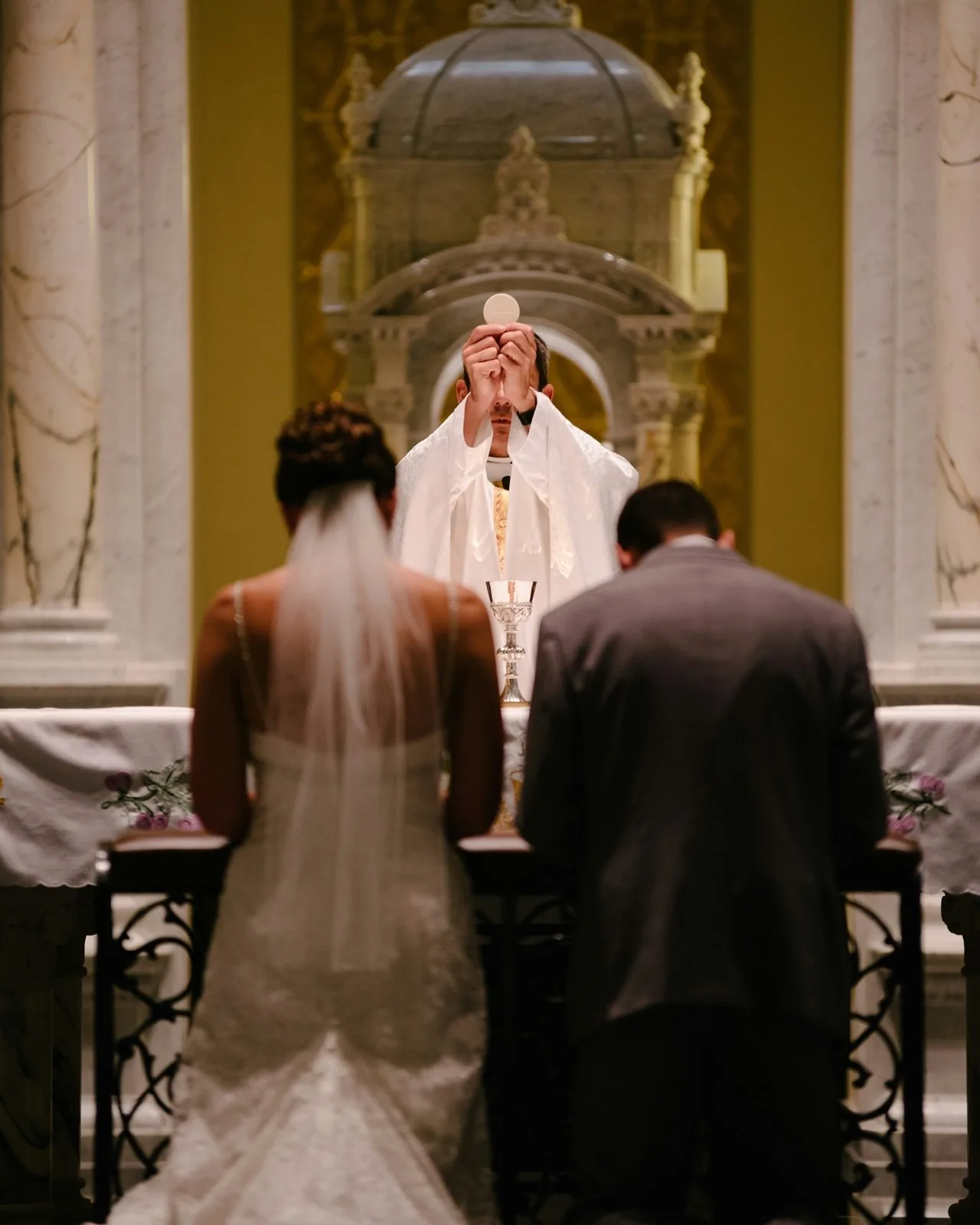 A Catholic couple praying together in a candlelit church